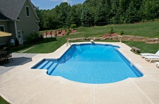 R oman in ground pool in Ballston, NY with custom pavers, and steps by Cypress Pools