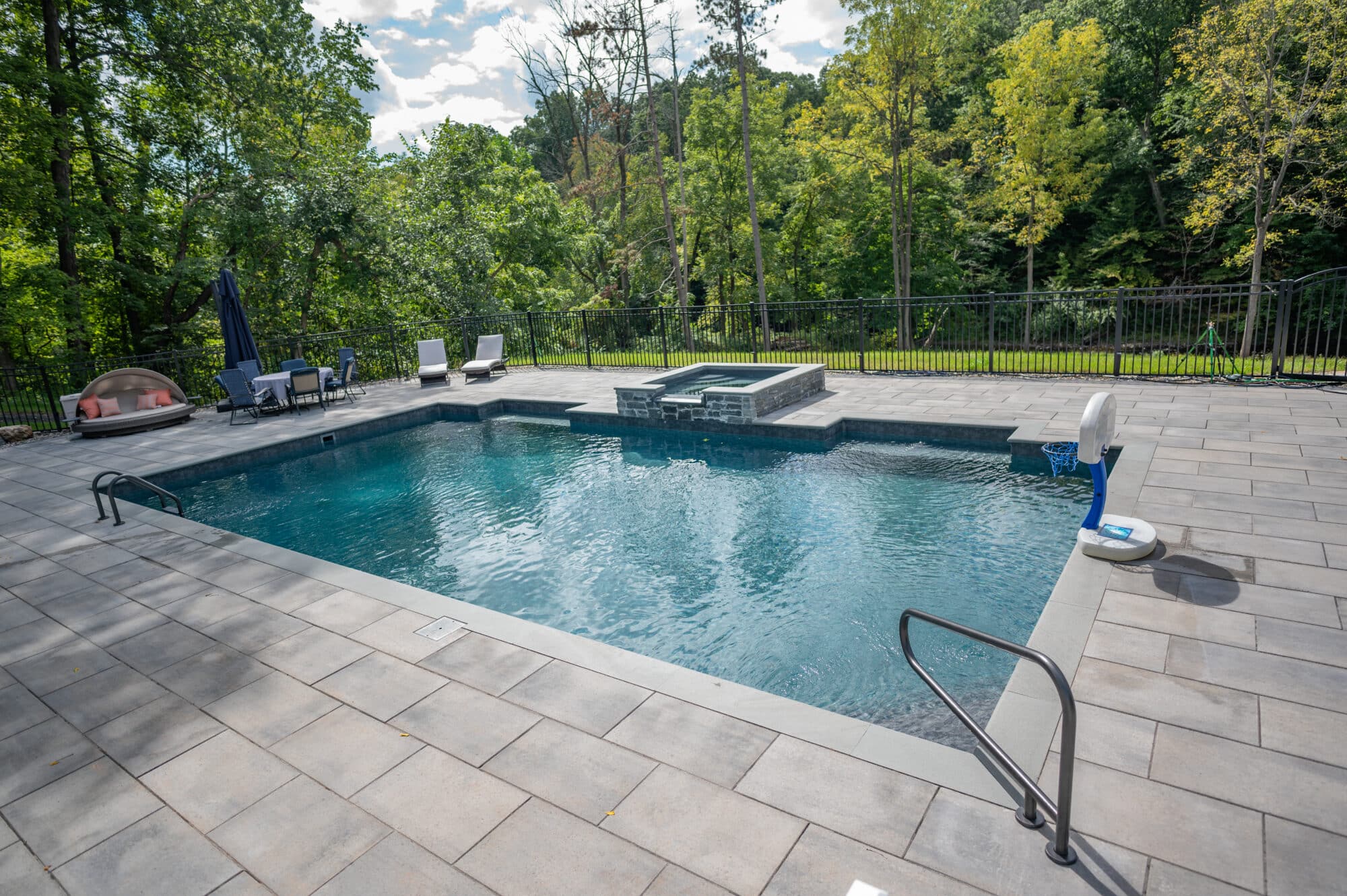 Custom Rectangle Inground Pool with basketball hoop, patio table and lounge chaise installed in Colonie, New York by Cypress Pools